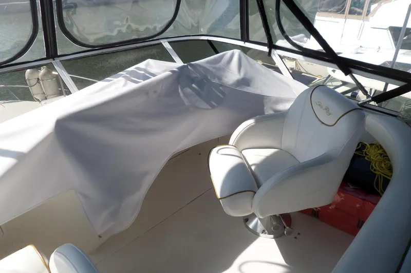 Slide: The Image of 2000 Sea Ray 380 Aft Cabin interior with white captain's chair and covered dashboard. - 9