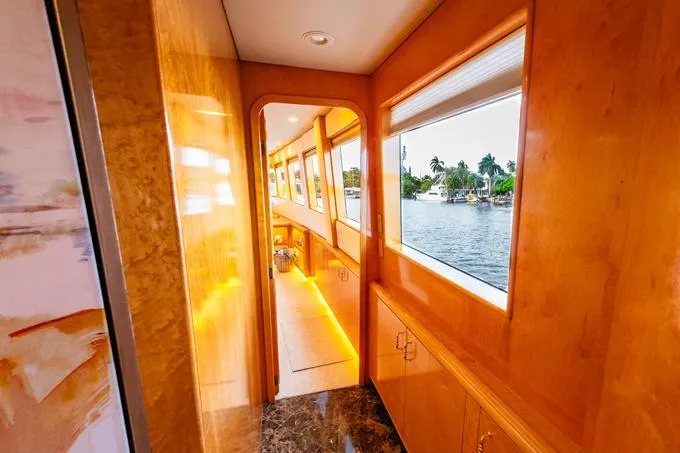 Slide: The Image of Luxurious 1995 Hatteras Motor Yacht interior with wood paneling and waterfront view. - 11