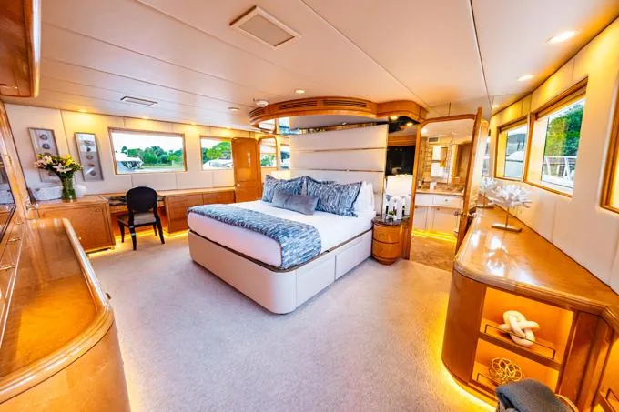 Slide: The Image of Luxurious 1995 Hatteras Motor Yacht bedroom with elegant wood finishes and ambient lighting. - 13