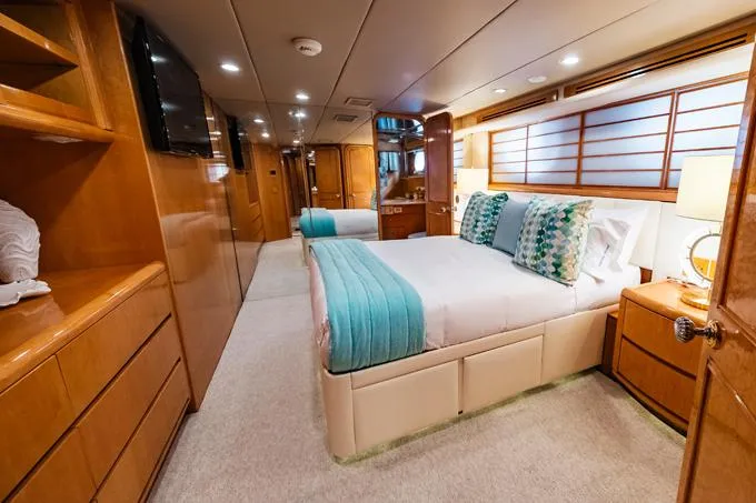 Slide: The Image of Luxurious 1995 Hatteras Motor Yacht bedroom with elegant wood finishes and modern decor. - 24