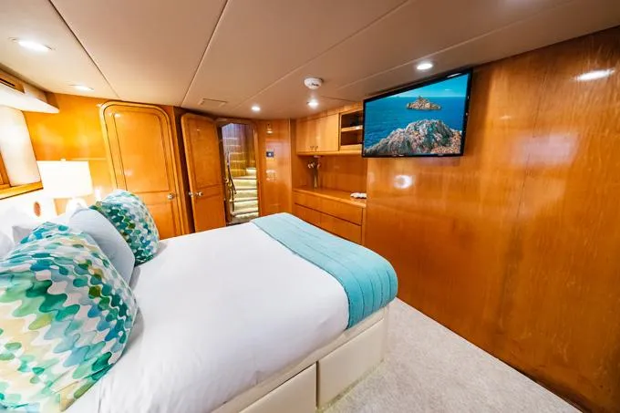 Slide: The Image of Luxurious 1995 Hatteras Motor Yacht bedroom with wood paneling and modern decor. - 25