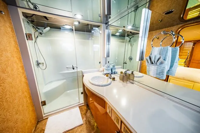 Slide: The Image of Luxurious bathroom in a 1995 Hatteras Motor Yacht with modern fixtures and glass shower. - 27
