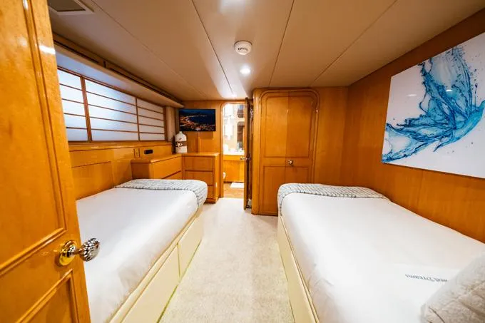 Slide: The Image of Luxurious 1995 Hatteras Motor Yacht cabin with twin beds and elegant wood paneling. - 37