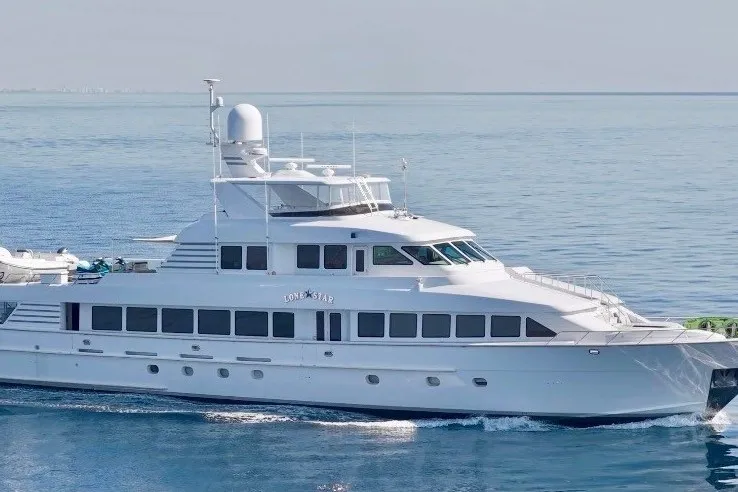 Slide: The Image of 1995 Hatteras 130 Motor Yacht cruising on calm blue waters. - 113