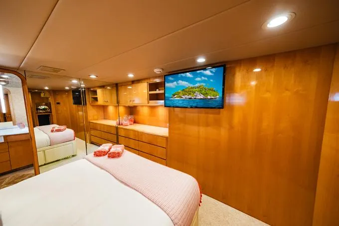 Slide: The Image of Luxurious 1995 Hatteras Motor Yacht bedroom with wood paneling and mounted TV. - 29