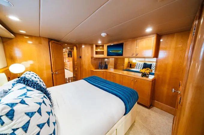 Slide: The Image of Luxurious 1995 Hatteras Motor Yacht bedroom with elegant wood paneling and modern decor. - 34