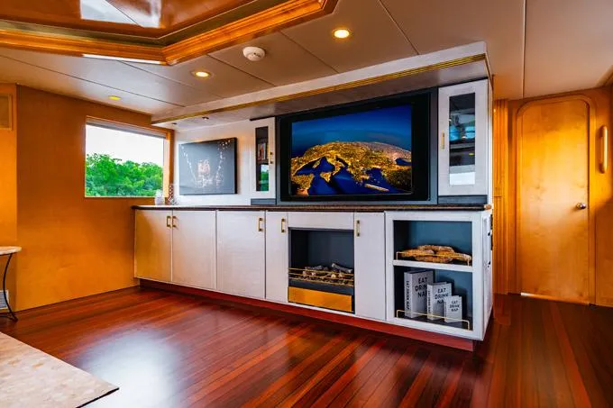 Slide: The Image of Luxurious interior of a 1995 Hatteras Motor Yacht with elegant wood flooring and modern entertainment system. - 43