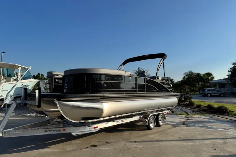 The Image of 2026 Bennington 24 MSB pontoon boat on trailer under clear blue sky. - 1