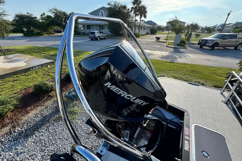 Slide: The Image of 2026 Bennington 24 MSB with Mercury outboard engine, parked outdoors. - 22