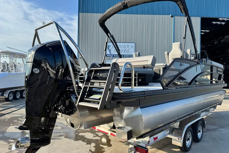 Slide: The Image of 2026 Bennington 24 MSB pontoon boat on trailer, featuring a powerful outboard motor. - 3