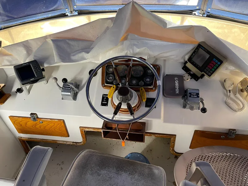 Slide: The Image of 1977 Pequod 34 Sportfish boat helm with steering wheel, navigation instruments, and controls. - 13