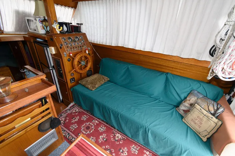 Slide: The Image of Interior of a 1977 Pequod 34 Sportfish boat with a cozy seating area and helm station. - 16
