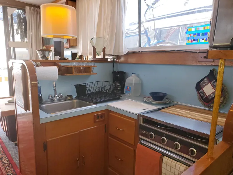 Slide: The Image of 1977 Pequod 34 Sportfish boat kitchen with sink, stove, and storage cabinets. - 23