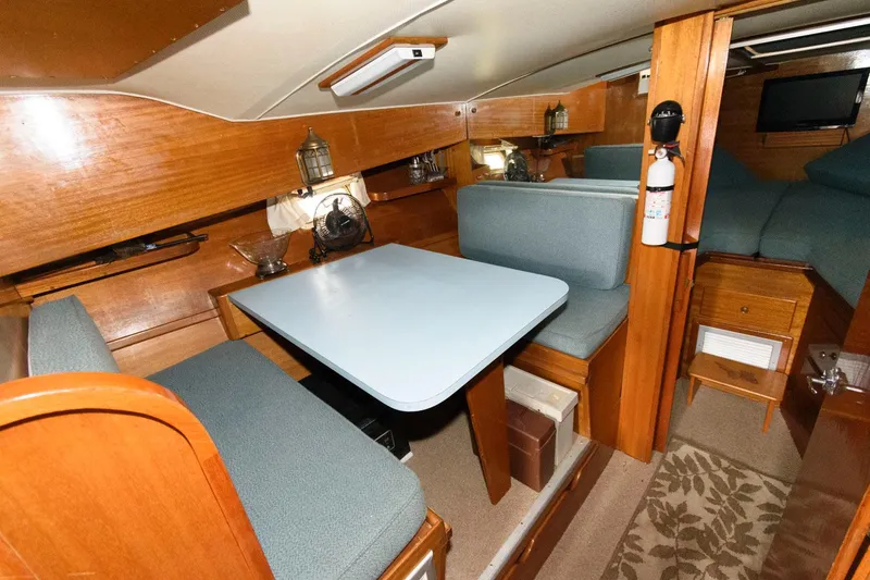 Slide: The Image of 1977 Pequod 34 Sportfish boat interior with dining area and wooden furnishings. - 24