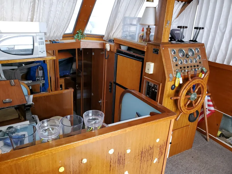 Slide: The Image of Interior of a 1977 Pequod 34 Sportfish boat with wooden helm and nautical decor. - 30