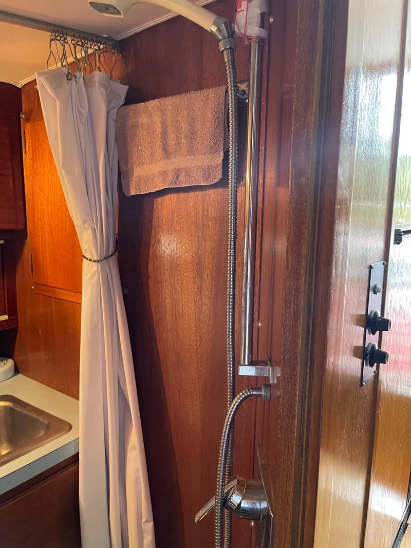 Slide: The Image of Shower area in a 1977 Pequod 34 Sportfish boat with wooden paneling. - 32