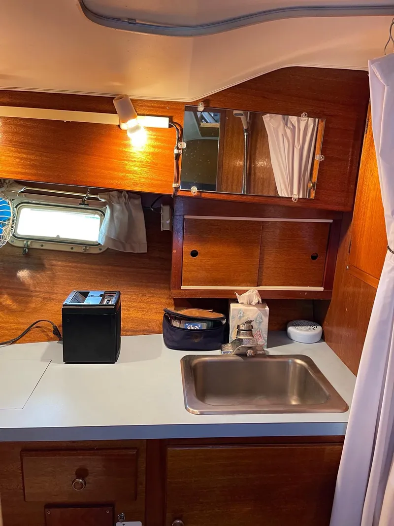 Slide: The Image of 1977 Pequod 34 Sportfish boat interior kitchen with sink and storage. - 33