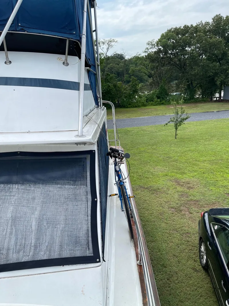 Slide: The Image of 1977 Pequod 34 Sportfish boat docked on grassy area near trees and a car. - 4