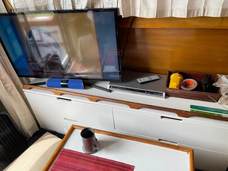 Slide: The Image of Interior of 1977 Pequod 34 Sportfish boat with TV, remote, and table. - 42