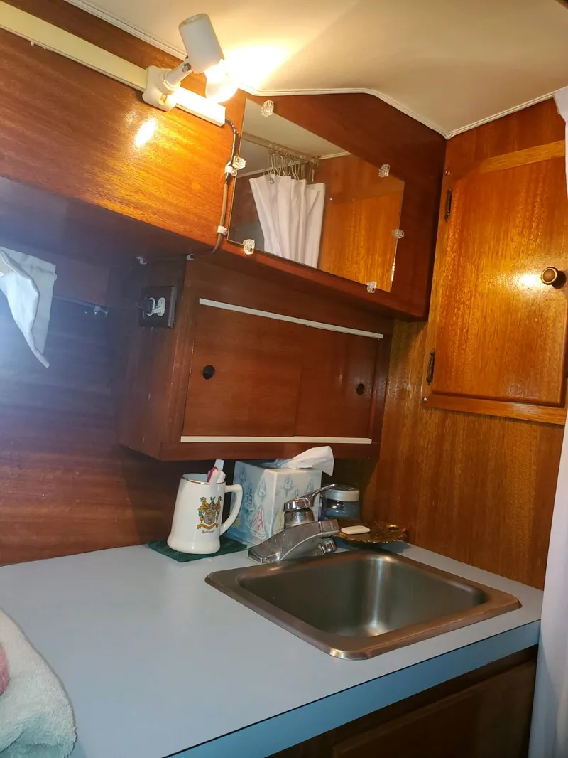 Slide: The Image of 1977 Pequod 34 Sportfish boat kitchen with wooden cabinets and sink. - 44