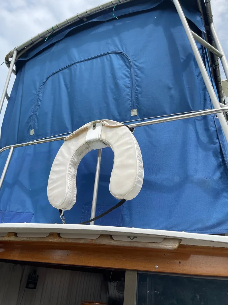 Slide: The Image of 1977 Pequod 34 Sportfish boat with blue canvas and life preserver. - 5