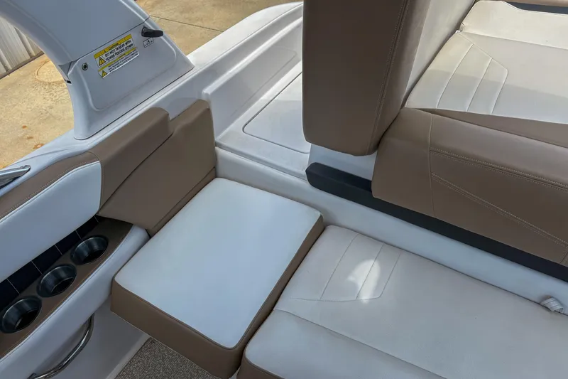 Slide: The Image of 2016 Four Winns H210 boat interior with beige and white seating and cup holders. - 10