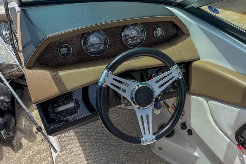 Slide: The Image of Steering wheel and dashboard of 2016 Four Winns H210 boat, featuring gauges and controls. - 6