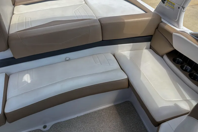 Slide: The Image of 2016 Four Winns H210 boat interior with beige and white seating, cup holders visible. - 9