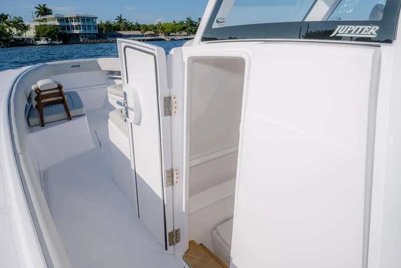 Slide: The Image of 2026 Jupiter 340LS boat interior with open cabin door, dockside view. - 20