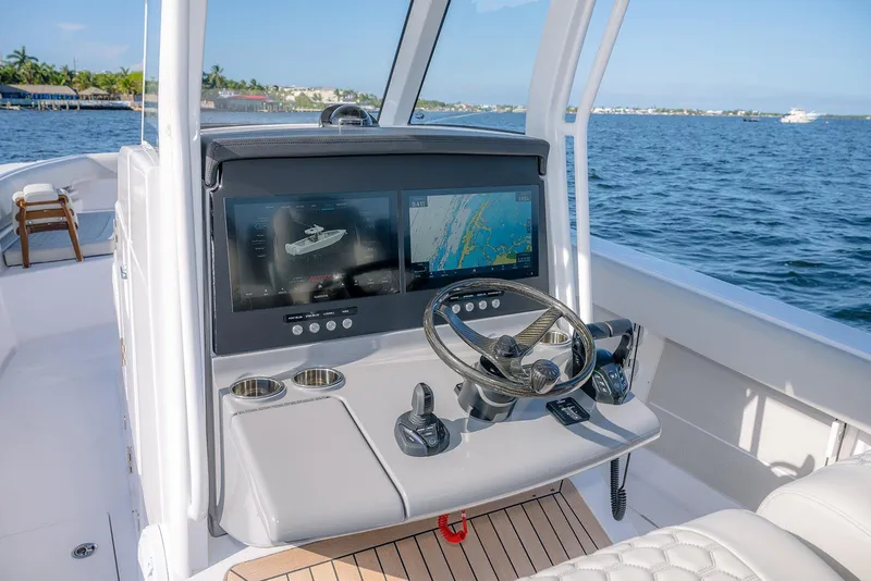 Slide: The Image of 2026 Jupiter 340LS boat cockpit with advanced navigation screens and steering wheel on open water. - 29