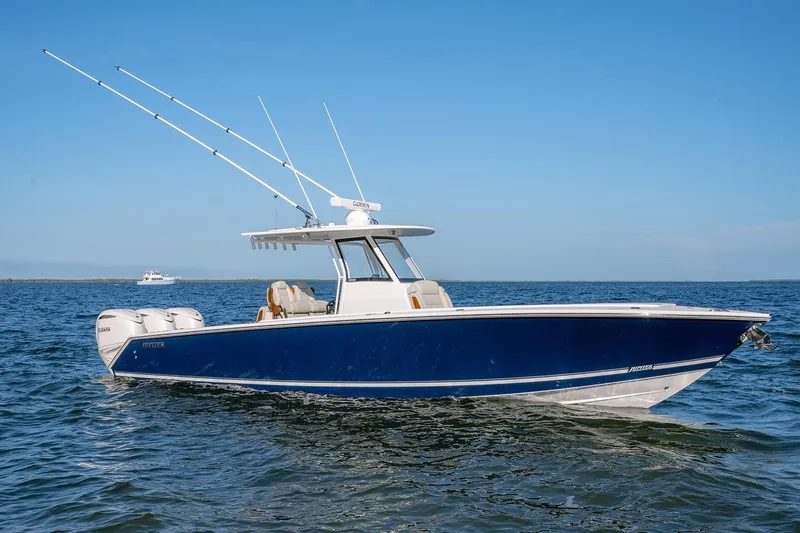 Slide: The Image of 2026 Jupiter 340LS boat on open water, featuring sleek blue design and fishing rods. - 3