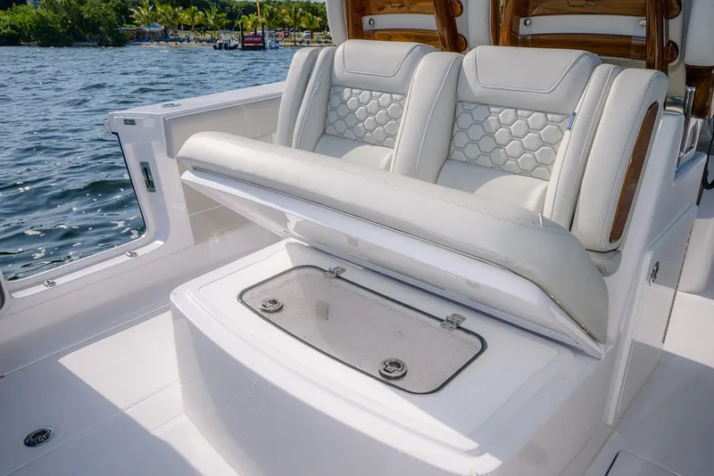 Slide: The Image of Luxury seating on 2026 Jupiter 340LS boat with storage compartment, near water. - 38