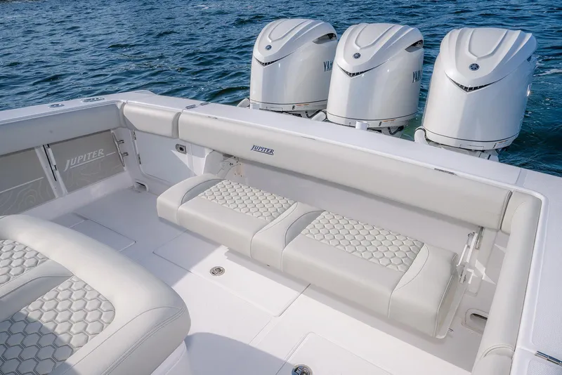 Slide: The Image of 2026 Jupiter 340LS boat interior with cushioned seating and triple outboard engines on the water. - 43