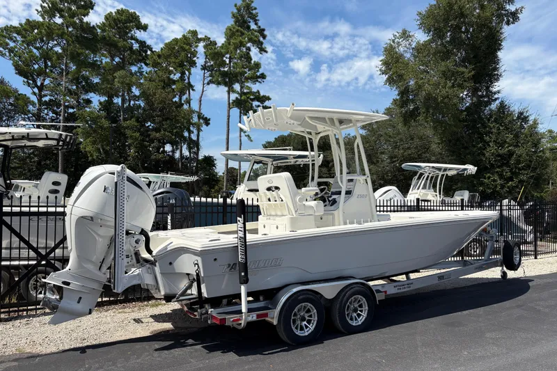 Slide: The Image of 2024 Pathfinder 2500 Hybrid boat on trailer, parked outdoors with trees in background. - 3