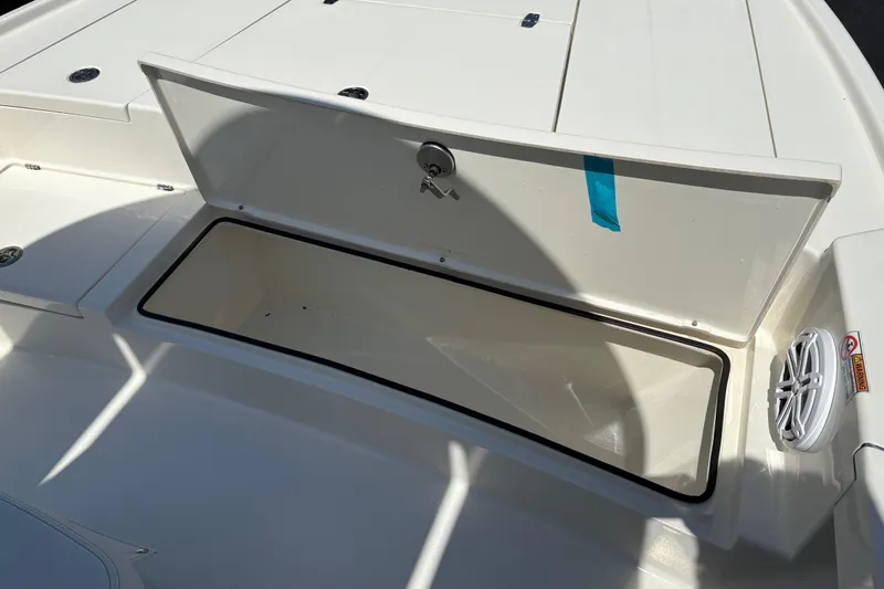 Slide: The Image of 2024 Pathfinder 2500 Hybrid boat storage compartment with open lid and speaker detail. - 7