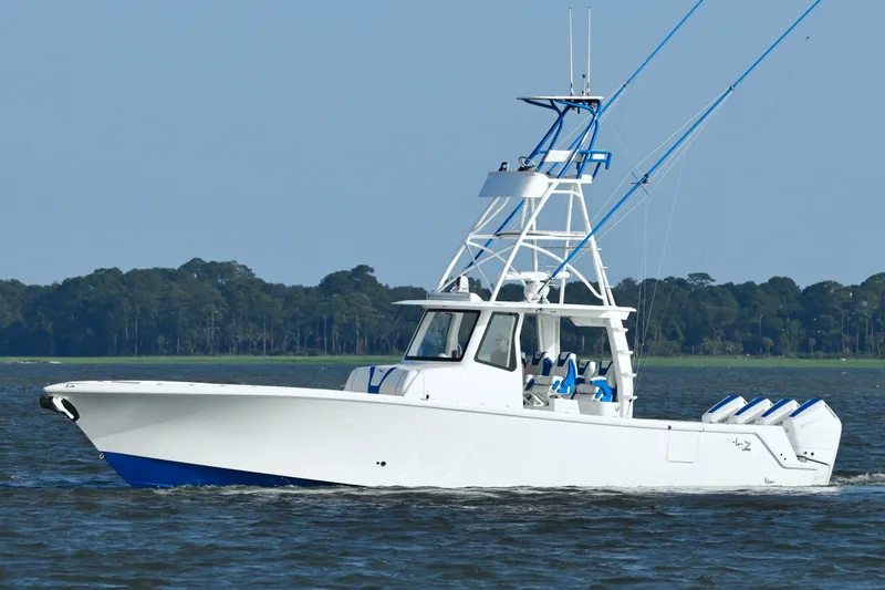 Slide: The Image of 2024 SeaVee 420Z boat cruising on water with forested shoreline in background. - 10