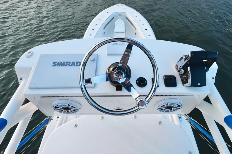 Slide: The Image of 2024 SeaVee 420Z boat helm with Simrad electronics and steering wheel, on calm water. - 16