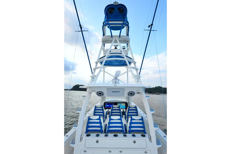 Slide: The Image of 2024 SeaVee 420Z boat with blue-striped seating and tower, on calm water. - 17