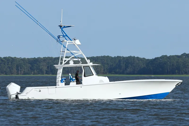 Slide: The Image of 2024 SeaVee 420Z boat cruising on water with forested shoreline in background. - 8