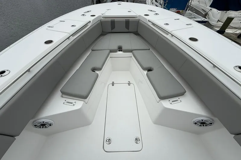 Slide: The Image of 2022 Cape Horn 34 XS boat interior with gray cushioned seating and storage compartments. - 16