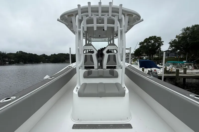 Slide: The Image of 2022 Cape Horn 34 XS boat interior with seating and rod holders, docked by a lake. - 24