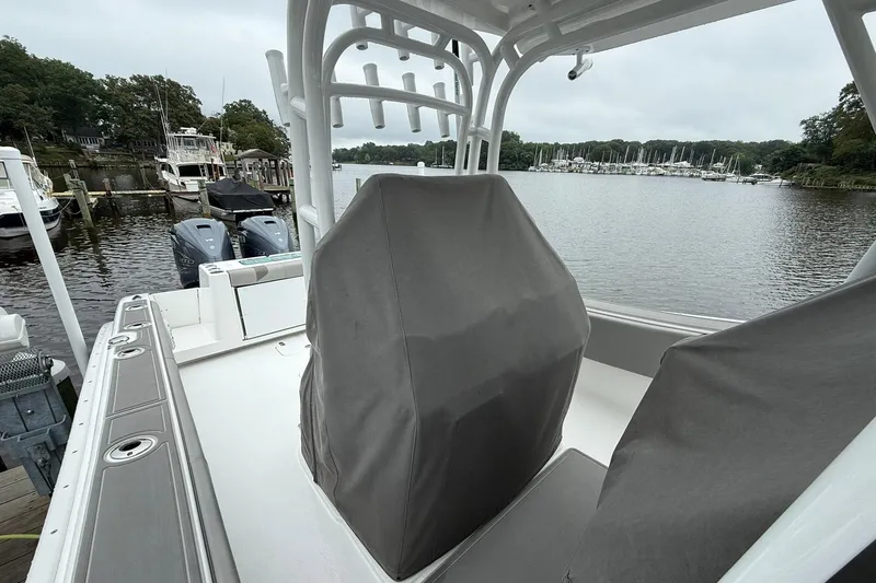 Slide: The Image of 2022 Cape Horn 34 XS boat docked, featuring covered seats and twin outboard motors. - 15