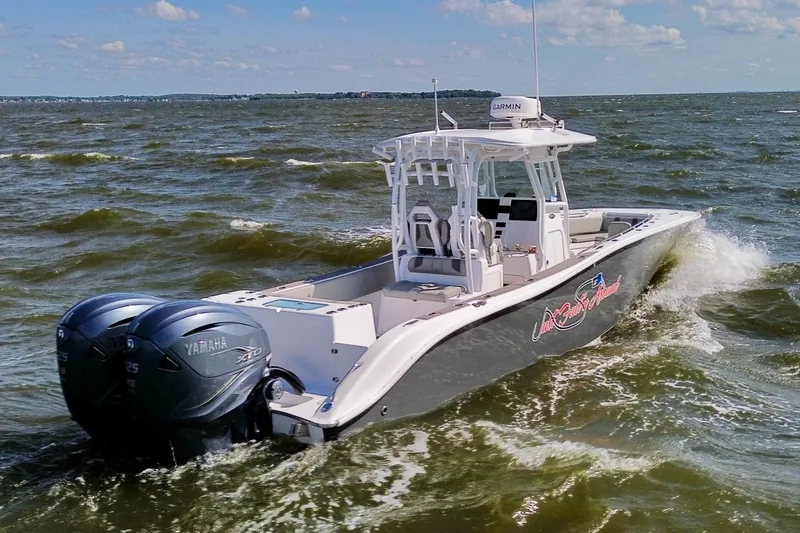 Slide: The Image of 2022 Cape Horn 34 XS boat navigating choppy waters with dual Yamaha engines. - 31