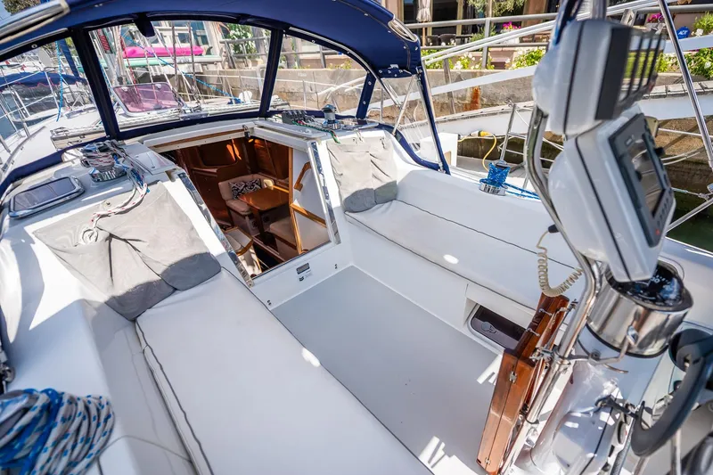 Slide: The Image of 2005 Catalina 36 MkII sailboat cockpit with open cabin, white seating, and navigation equipment. - 12