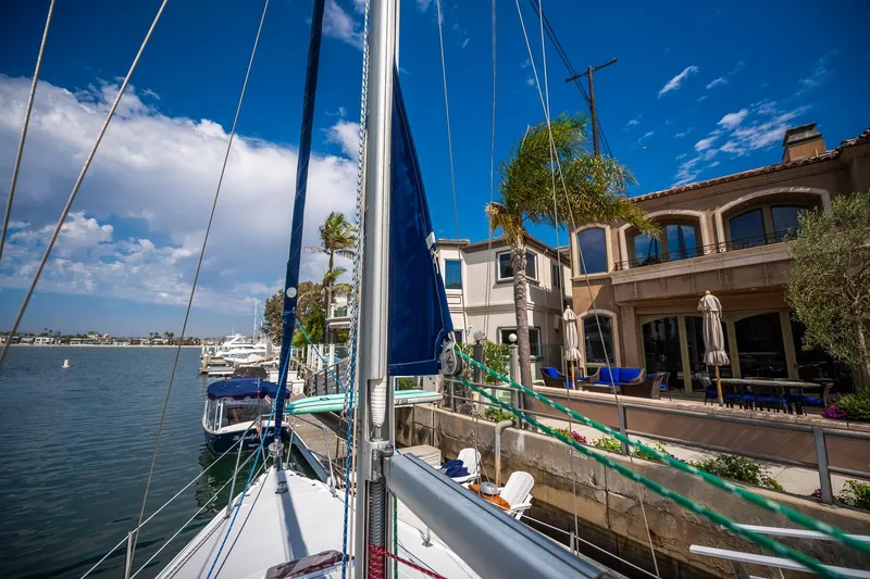 Slide: The Image of Sailboat Catalina 36 MkII, 2005, docked near waterfront homes under a clear blue sky. - 14