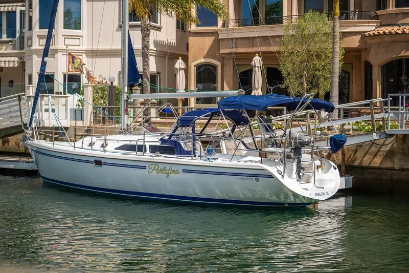 Slide: The Image of 2005 Catalina 36 MkII sailboat docked in a marina, featuring blue accents and canopy. - 2