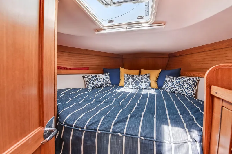 Slide: The Image of Cozy cabin interior of 2005 Catalina 36 MkII sailboat with striped bedding and decorative pillows. - 21