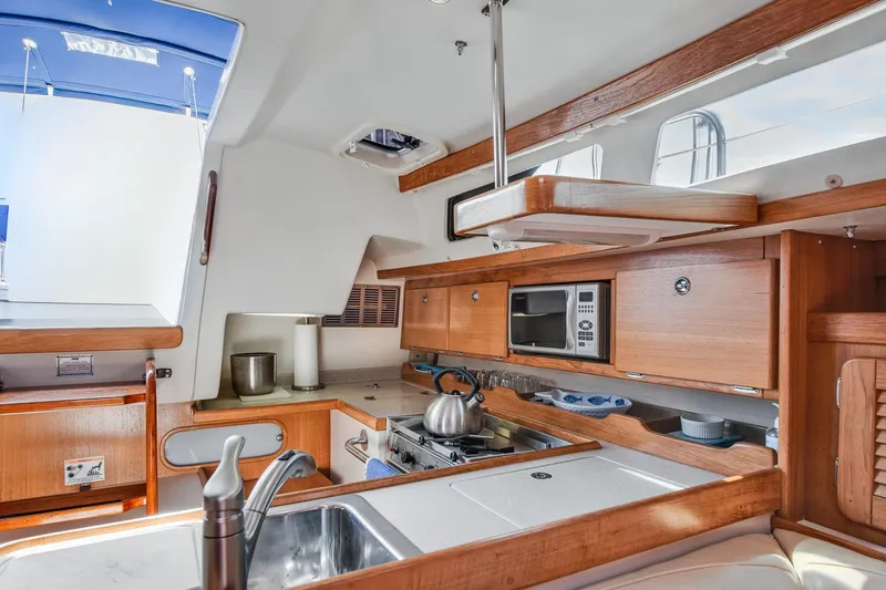 Slide: The Image of Interior of 2005 Catalina 36 MkII yacht kitchen with wooden cabinetry and modern appliances. - 26