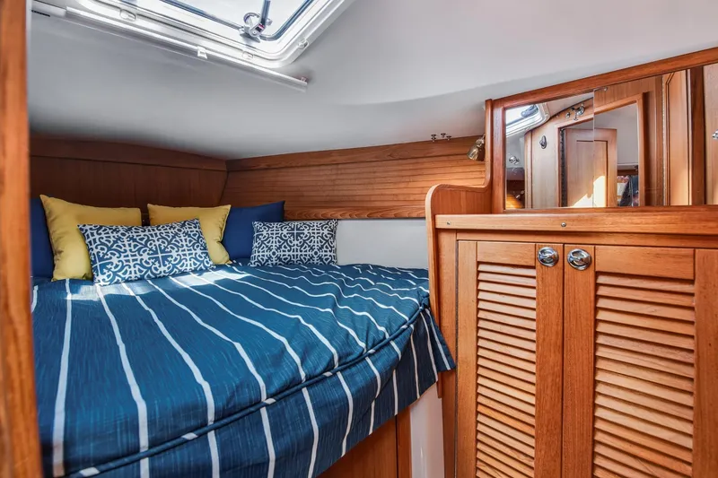 Slide: The Image of Cozy cabin interior of 2005 Catalina 36 MkII sailboat with striped bedding and wooden cabinetry. - 32