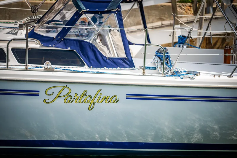 Slide: The Image of Catalina 36 MkII sailboat "Portofino" with blue accents, docked in a marina, 2005 model. - 4